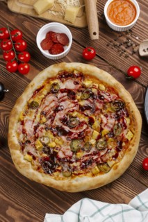 Pizza and ingredients on wooden table