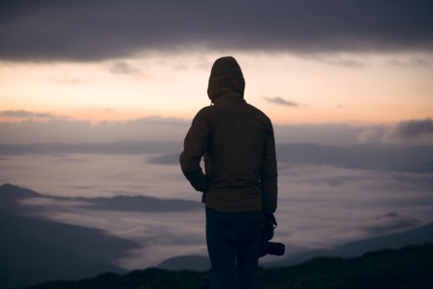 Silhouette of young man with camera at sunset in the Carpathian Mountain Range