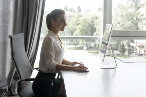 Young businesswoman working on desktop computer