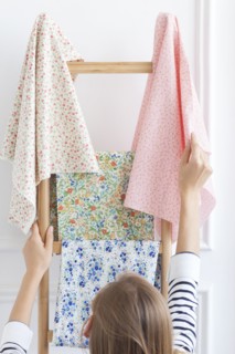 Woman choosing fabric from rack