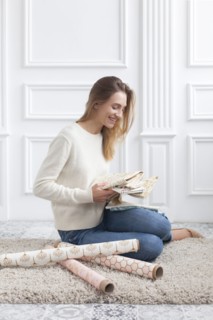 Woman sitting on rug with variety of fabrics