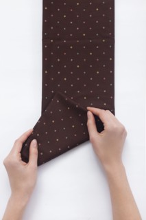 Hands of woman folding brown fabric