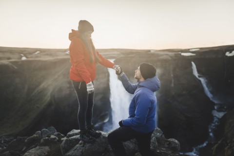 Young man proposing to his girlfriend while hiking by Haifoss waterfall in Iceland