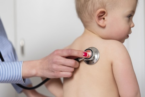 Paediatrician using stethoscope on girl