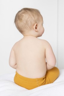 Shirtless girl sitting on bed
