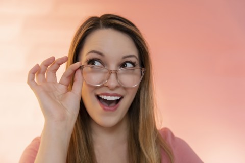Excited young woman wearing glasses