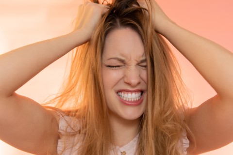 Stressed young woman with her hands in her hair