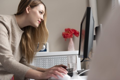 Young woman using desktop PC