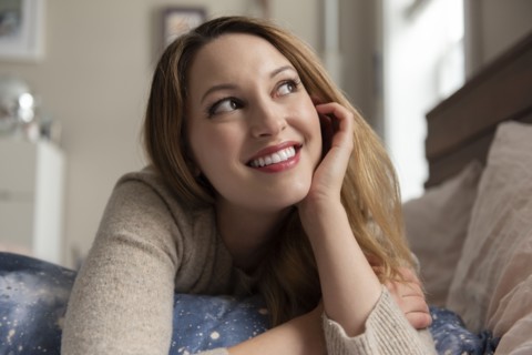 Young woman day dreaming on bed