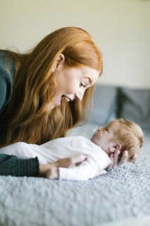 Woman holding her newborn son on bed