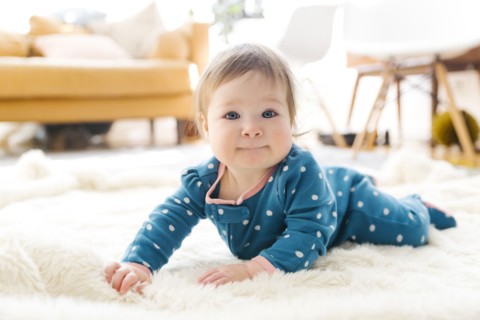 Baby girl lying on rug