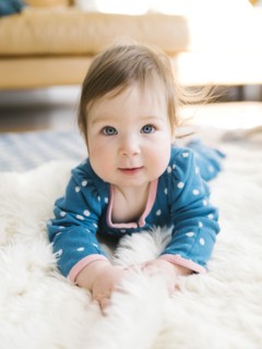 Baby girl lying on rug