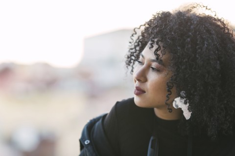 Portrait of young woman with curly black hair