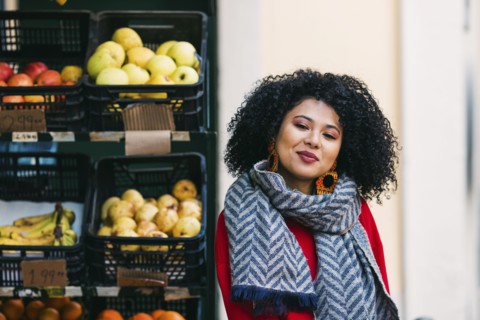 Young woman by crates of fruit