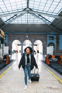 Young woman pulling suitcase in railway station