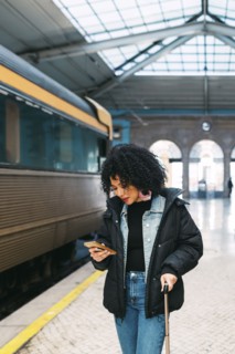 Young woman using smart phone in railway station