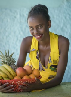 Smiling young woman holding fruit bowl