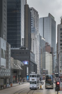 Double-decker tram and bus on street in Hong Kong, China