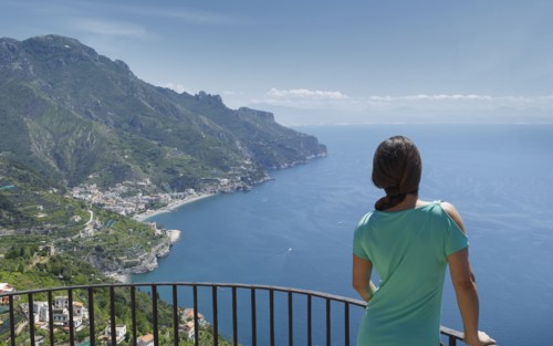Woman leaning on railing by Amalfi Coast, Italy