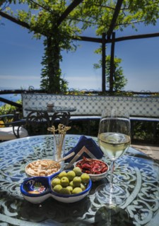 Antipasto and wine on dining table under pergola
