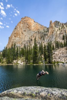 Man diving into lake by mountain in Stanley, Idaho, USA