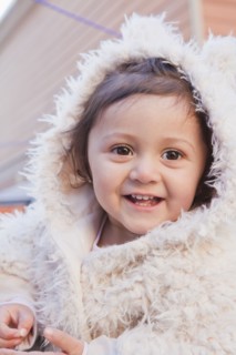 Portrait of smiling girl wearing white fur hood