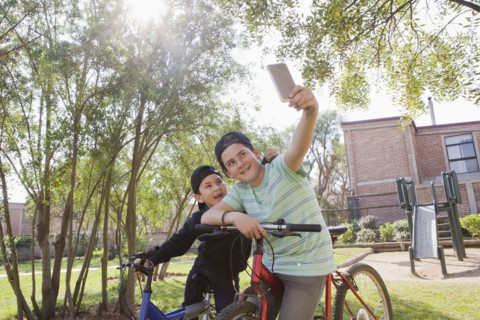 Brothers taking selfie on bicycles