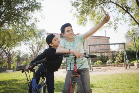 Brothers taking selfie on bicycles