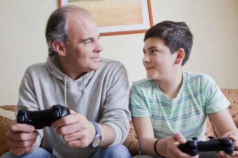 Father and teenage son playing video game
