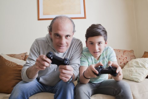 Father and teenage son playing video game