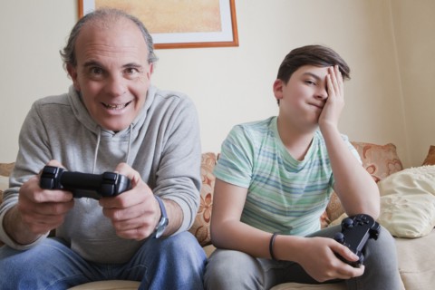 Father and teenage son playing video game
