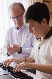 Father teaching his son piano