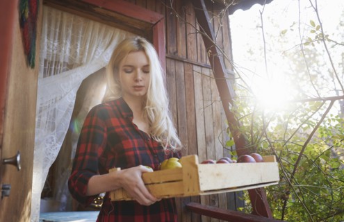 Young woman holding crate of apples