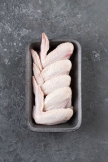Raw chicken wings in roasting pan
