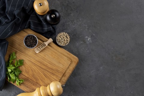 Pepper and pepper mills on cutting board