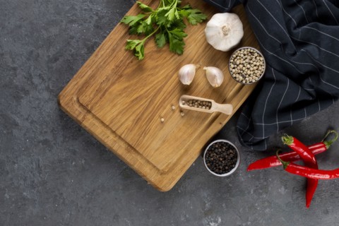 Pepper, garlic and parsley on cutting board by chili peppers