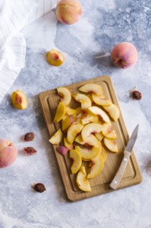 Peaches sliced on wooden cutting board