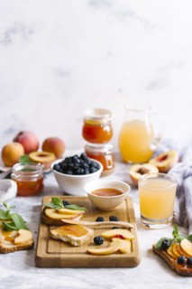 Breakfast spread with blackberries, peaches, toast and apricot jam