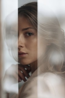 Portrait of young woman behind window