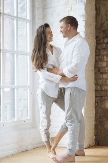 Smiling couple embracing by window