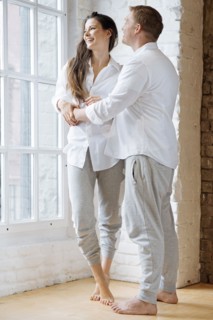 Smiling couple embracing by window
