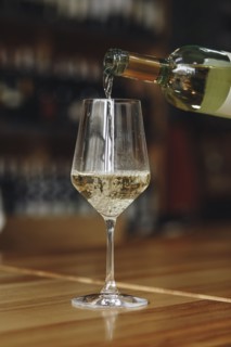 White wine poured from bottle into wineglass