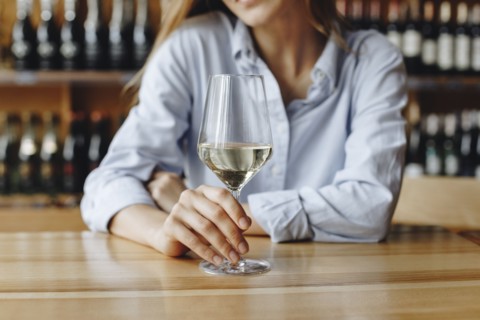 Woman holding glass of white wine