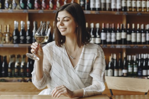 Smiling young woman holding glass of white woman