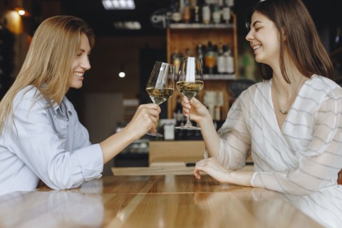 Young women toasting with glasses of white wine