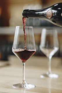 Red wine poured from bottle into wineglass
