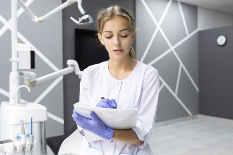 Dental assistant writing notes