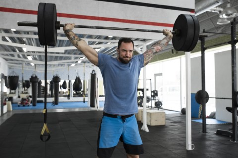 Mid adult man weight lifting in gym
