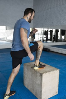 Man stepping onto box in gym