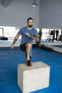 Man stepping onto box in gym